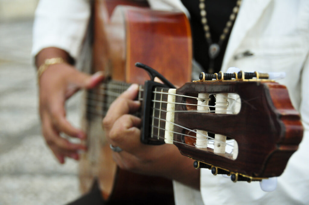 Close-up de mãos tocando violão para o Sarau Petrobras Cultural